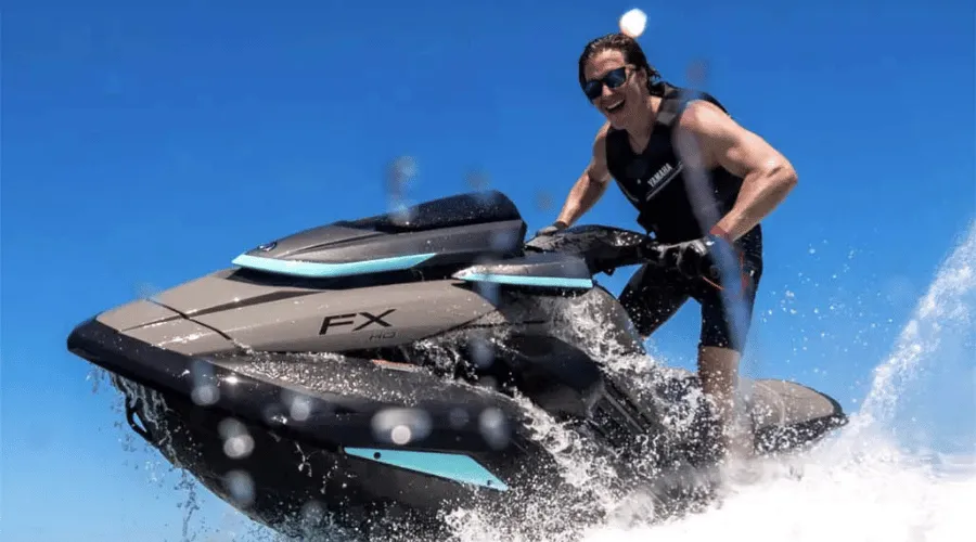 Pilote de jet-ski filant sur l'eau sous un ciel bleu
